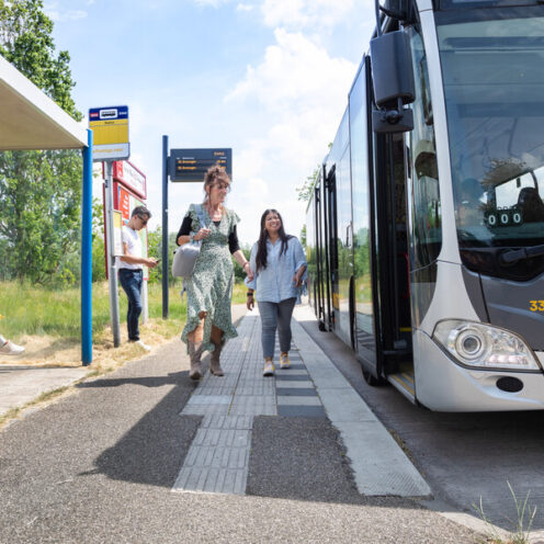 Reizigers stappen de bus in